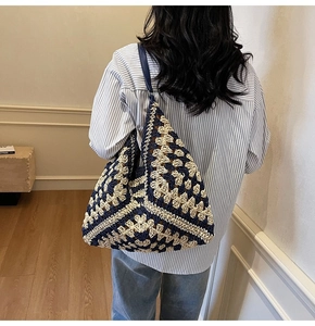 Detail of blue and beige woven tote bag with classic granny square crochet pattern