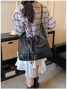 Detail of black punk tote bag with silver zippers, metal rivets and belt buckle accents