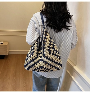 Detail of navy and beige granny square hand-crocheted hobo tote bag with shoulder strap
