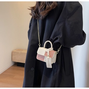 Pink and white color-block mini bag with chain strap styled on a black wool coat
