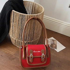 Détail du sac à main rétro rouge avec sangles en cuir et coutures blanches apparentes