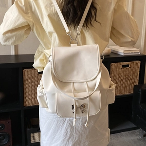 Vue détaillée d'un sac à dos en cuir PU blanc crème avec un nœud argenté à l'arrière