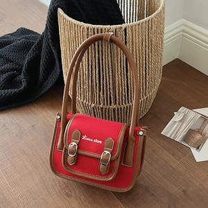 Vue détaillée du sac en toile rouge avec bordures en cuir brun et broderie Luuuu