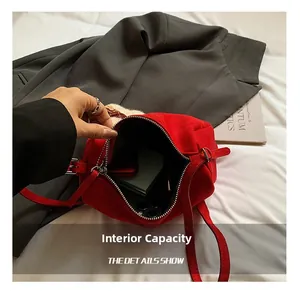 Macro shot of red suede bag showing silver zipper and large interior storage space