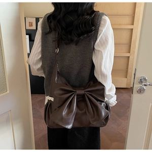Detail of the large vintage leather bow and delicate lace trim on the shoulder bag