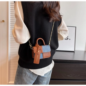 Detailed back view of a mini contrast color chain bag worn by a model in a modern home