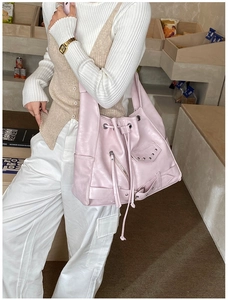 Detail of light pink punk tote bag with silver rivets and decorative zippers