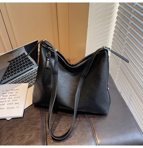 Vue détaillée du sac hobo noir en cuir légèrement brillant avec fermeture éclair sur le dessus