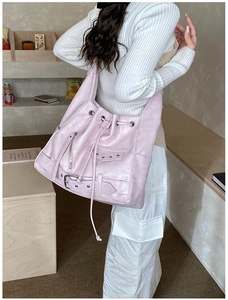 Close-up of pink punk style hobo bag with rivets, zippers and drawstring details