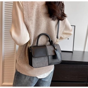 Detail showing the mixed-material texture and branded tag of the elegant square crossbody bag