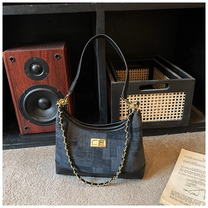 Detail of grey checkered fabric handbag with gold chain strap and vintage twist lock