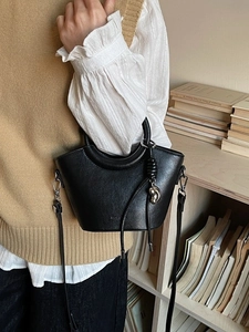 Sac seau élégant en cuir noir avec détails argentés dans un décor de style de vie