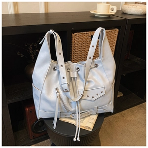 Detail of ice blue punk tote with silver rivets, metal eyelets and drawstring closure