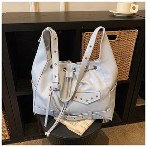 Detailed view of punk style tote bag with rivets, zippers, and drawstring closure