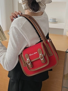 Sac bandoulière chic en toile rouge avec bordure en cuir marron et boucles vintage