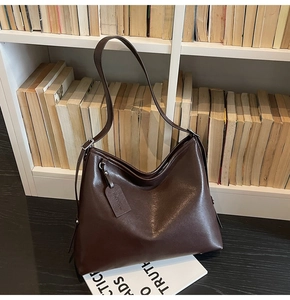 Détail du sac hobo en cuir marron foncé avec bandoulière réglable et finition brillante