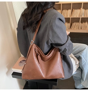 Vue détaillée du sac hobo en cuir marron avec rivets et bandoulière réglable
