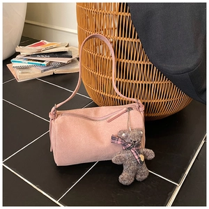 Detailed close-up of pink pillow bag with cute plush bear charm in a retro setting