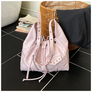Close-up of light pink punk tote bag featuring silver rivets and biker-style metal zippers
