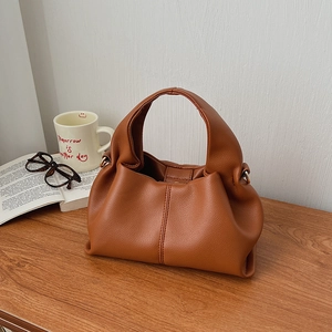 Detail of vintage brown cloud bag with lychee texture PU leather and metal D-rings