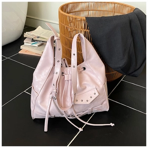 Detail shot of pale pink rivet tote bag with drawstring closure and punk vintage elements