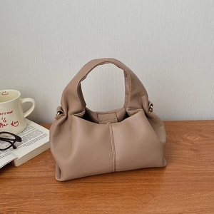 Detailed view of elephant gray soft leather pleats and metal ring on a cloud handbag