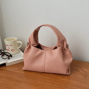 Close-up of pink cloud bag with lychee grain texture and gold metal hardware