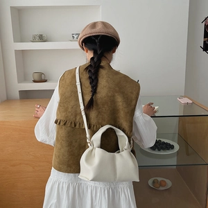 Detailed view of white cloud crossbody bag with soft litchi grain texture and strap