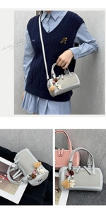 Detail view of stylish cylinder shoulder bags with cute bear pendants and dual zip closure
