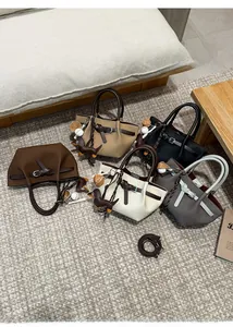 Draufsicht auf bunte Eimertaschen mit Leder-Hundeanhängern auf grauem Teppichboden
