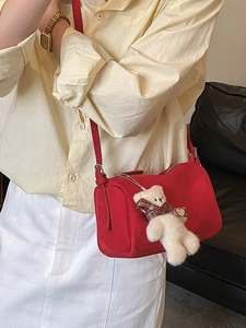 Chic red suede pillow bag for women with cute teddy bear charm and sleek shoulder strap
