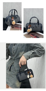 Detail view of navy tweed Boston bag with plush bear charm and sleek metal hardware