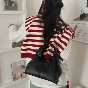 Close-up of black lychee grain leather cloud bag with shoulder strap and chic texture