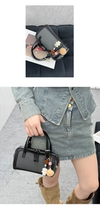 Detail of mini Boston handbag with bear charm and pom-pom accessory in gray patchwork