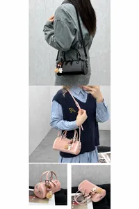 Detail view of cylindrical shoulder bag in black and pink with cute bear charm