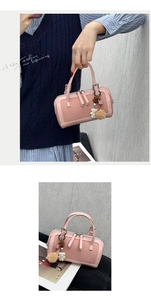 Pink woven Boston bag with cute bear charm and furry pom-pom detail on handle