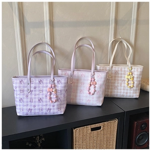 Detailed view of three tote bags featuring bear patterns and beaded bow charms