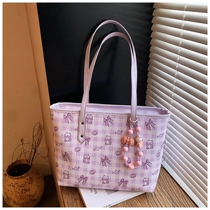 Purple plaid tote bag with cute bear print and beaded charm on a wooden desk