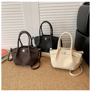 Détail de sacs cabas en cuir grainé litchi en marron, noir et blanc avec boucles en métal