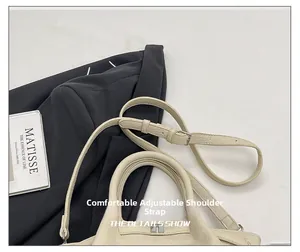 Détail du sac seau blanc cassé avec texture grainée et bandoulière réglable chic