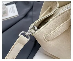 Vue détaillée des crochets métalliques argentés sur le sac à main en cuir beige