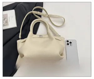 Détail du sac à main en cuir grainé blanc crème avec logo argenté et bandoulière