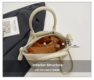 Détail de l'intérieur du sac seau en cuir beige avec poche principale et zippée