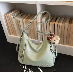 Detail of mint green hobo tote bag texture with cute bear charm and side zipper