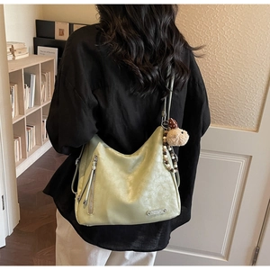 Detail of light green vintage hobo bag featuring silver zipper and bead charm with rabbit