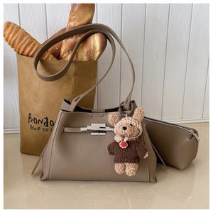 Detail of khaki leather tote bag with silver twist lock, mini pouch and teddy bear charm