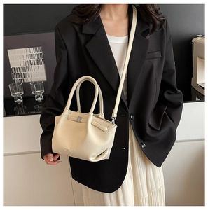 Détail du sac seau en cuir grainé avec boucle argentée et bandoulière réglable