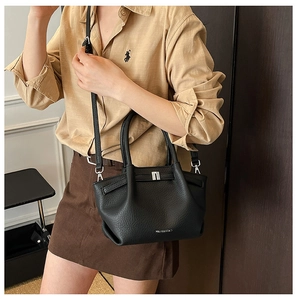 Détail du sac à main noir en cuir grainé avec finitions argentées et logo de marque