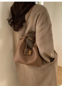 Braune Leder-Eimertasche kombiniert mit Wollmantel für einen schicken, modischen Look