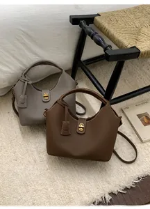 Detailansicht der Leder-Eimertaschen mit Metalldrehverschluss und Litchi-Struktur
